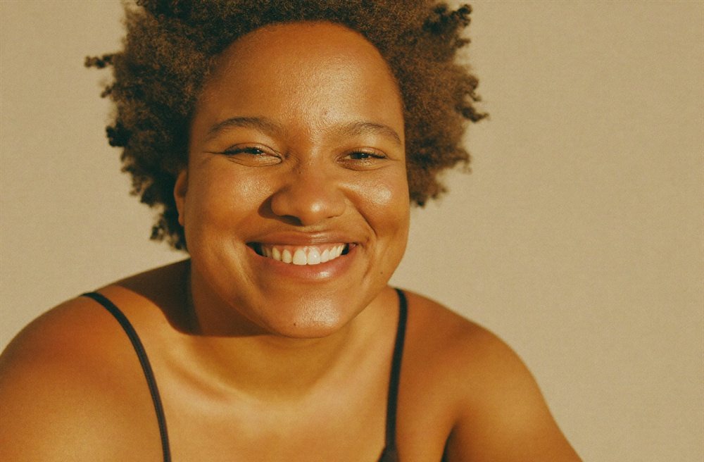 Portrait of a smiling person with natural curly hair