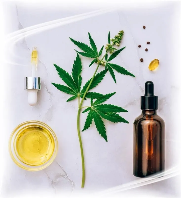 Cannabis leaves beside CBD oil, capsules and a dropper bottle